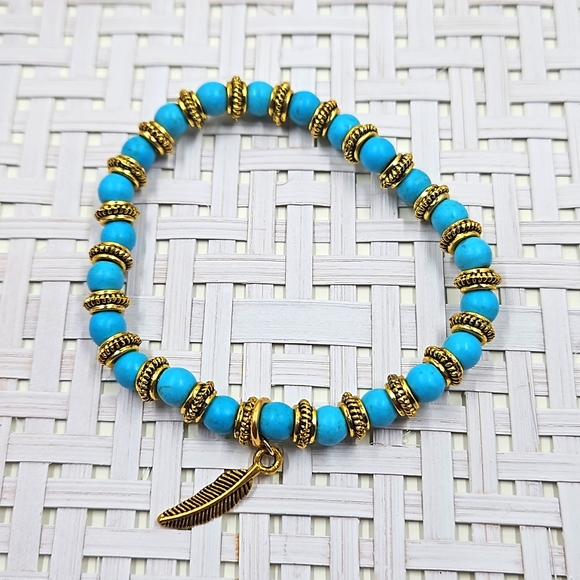 Hand Crafted Jewelry - Handmade blue howlite and gold spacer bead stretch bracelet with a gold feather